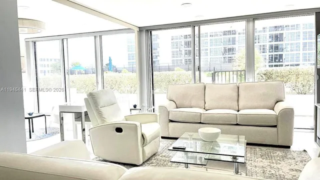 a living room with furniture and large windows