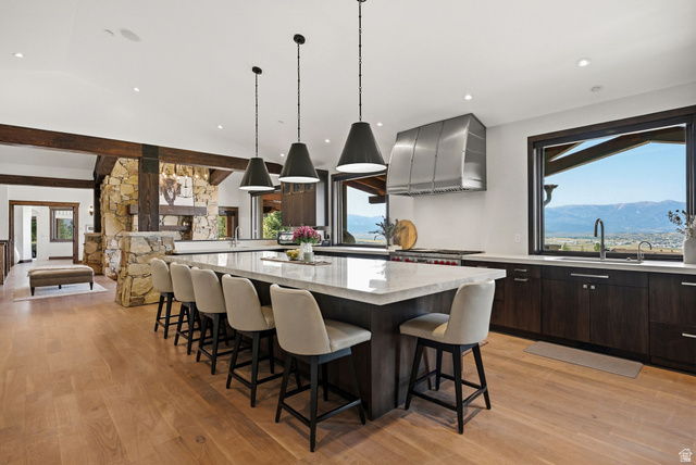 7885 North Rabbitbrush Court, Unit 13 Park City, UT 84098 - Photo 12 of 88 Spacious kitchen featuring a large central island with seating, a professional-grade range with a stainless steel hood, and extensive cabinetry