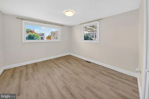 an empty room with wooden floor and window