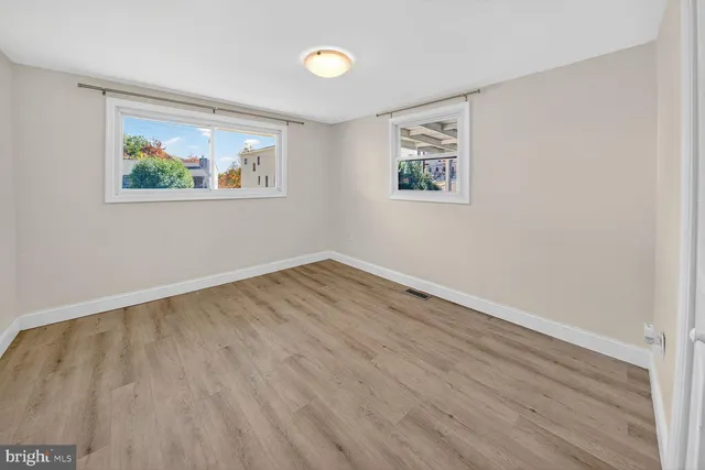 an empty room with wooden floor and window