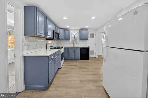 a large kitchen with stainless steel appliances granite countertop a refrigerator and a sink