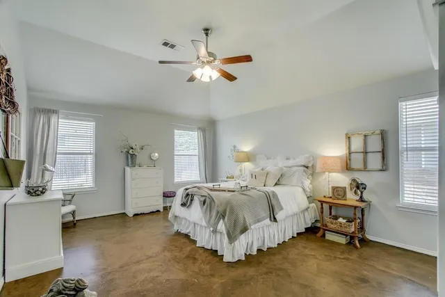 a spacious bedroom with a bed and a chandelier