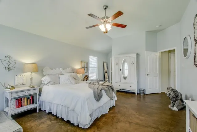 a spacious bedroom with a bed and a chandelier