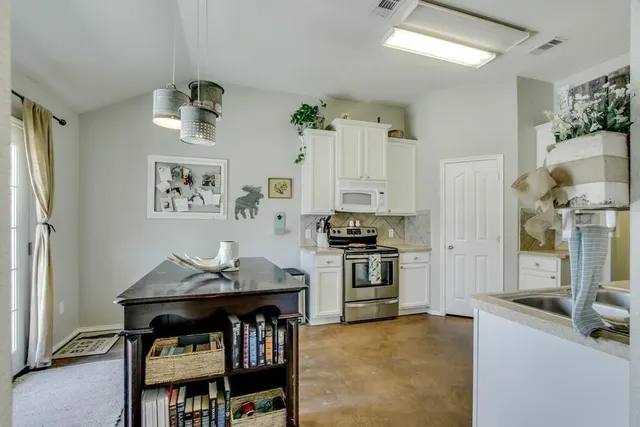 a kitchen with stainless steel appliances granite countertop a stove refrigerator and a stove