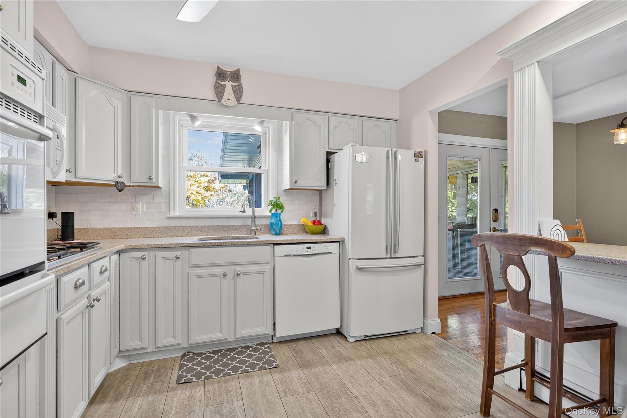 76 Pine Hill Road Highland Mills, NY 10930 - Photo 16 of 41 Kitchen with white appliances, decorative backsplash, a warming drawer, light wood-type flooring, and white cabinetry