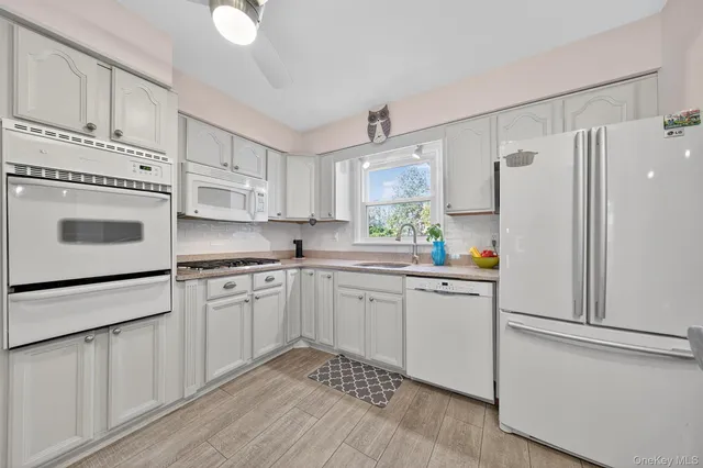 a kitchen with white cabinets and white appliances