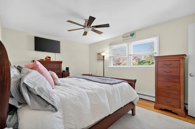 a bedroom with a bed and a flat tv screen on the dresser
