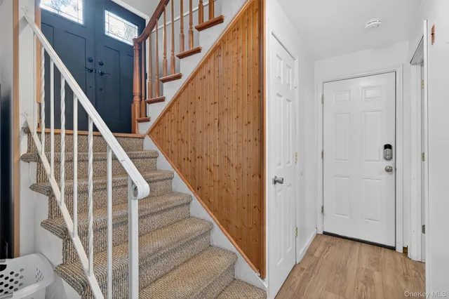 a view of staircase with wooden floor and white walls