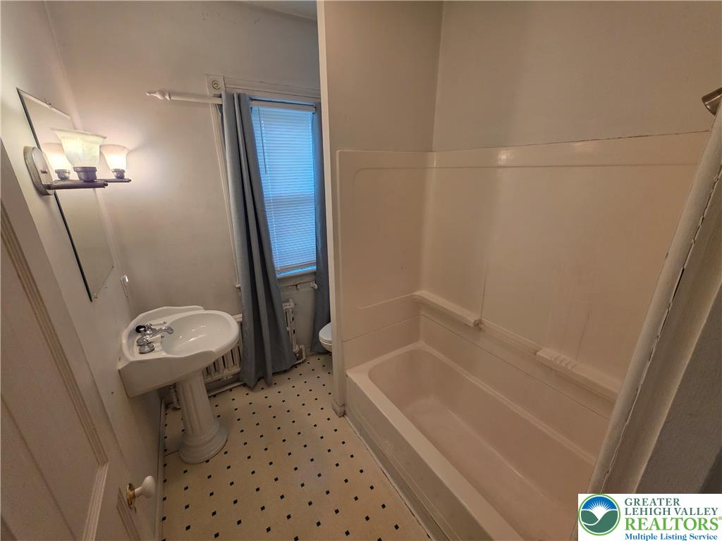 911 High Street Bethlehem, PA 18018 - Photo 10 of 15 A classic pedestal sink and tub-shower combo complete this functional bathroom space.