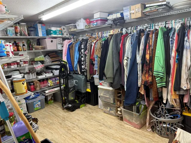 a view of walk in closet with clothes and shoes