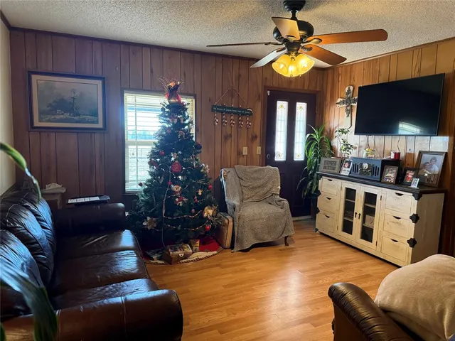a living room with furniture a flat screen tv and a chandelier