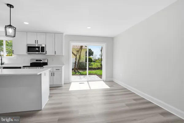 a kitchen with stainless steel appliances a white refrigerator a stove top oven a sink and dishwasher with wooden floor