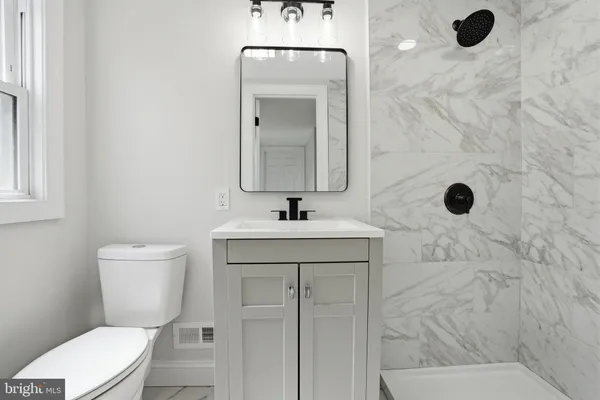 a bathroom with a toilet sink and mirror