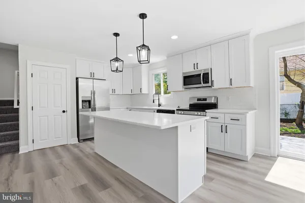 a kitchen with white cabinets and stainless steel appliances