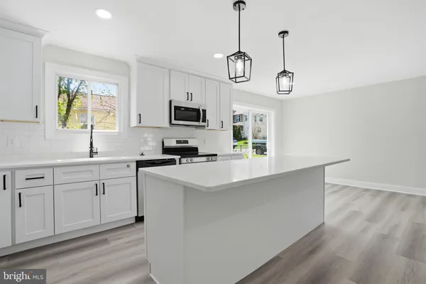 a kitchen with appliances cabinets a sink and a window