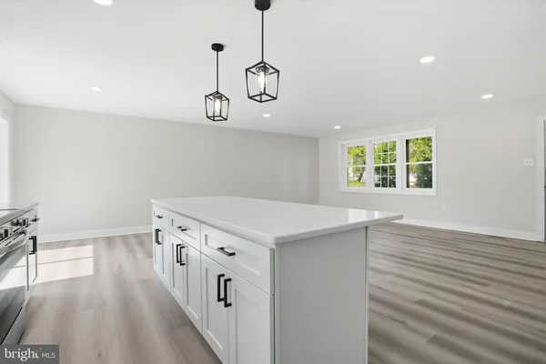 a hallway with a stove a wooden floor and windows