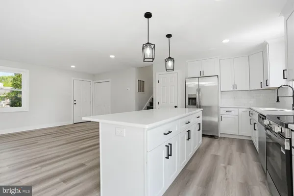 a kitchen with stainless steel appliances a white stove top oven a sink dishwasher and a refrigerator