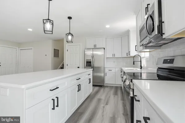 a kitchen with stainless steel appliances a stove sink and cabinets