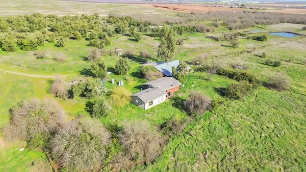 an aerial view of a house with swimming pool and garden