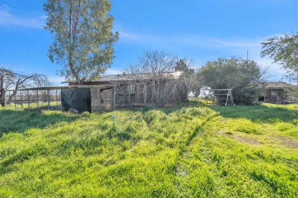 a house is sitting in middle od the grass