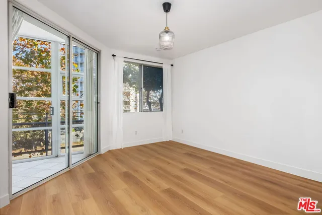 a view of a bedroom with wooden floor and windows
