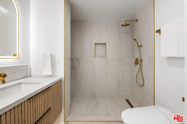 a bathroom with a granite countertop toilet sink and shower