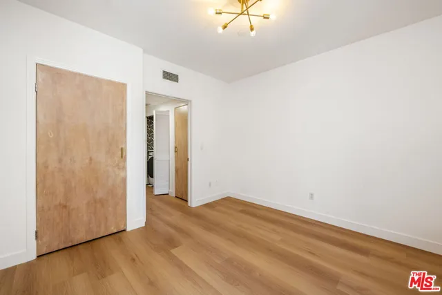 an empty room with a ceiling fan and wooden floor