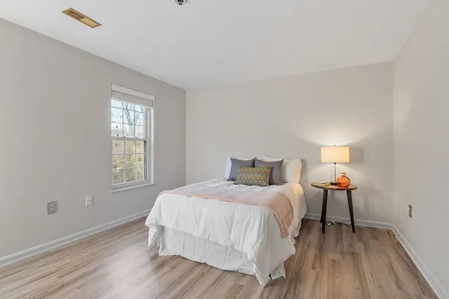 a bedroom with a bed and wooden floor