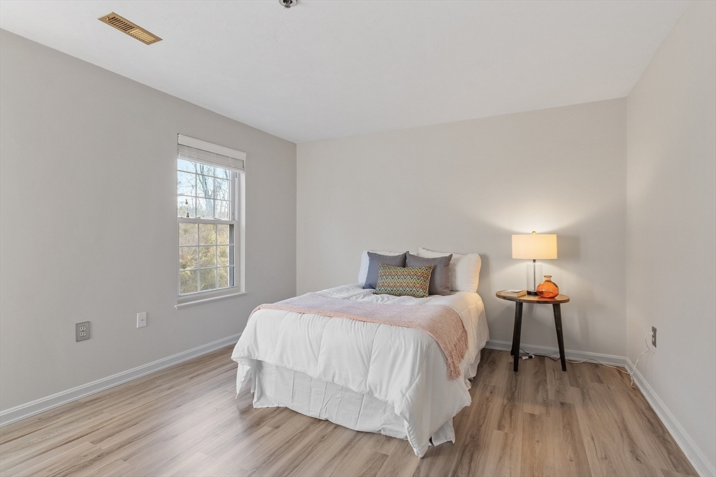 278 Manning Street, Unit 603 Hudson, MA 01749 - Photo 15 of 34 a bedroom with a bed and wooden floor