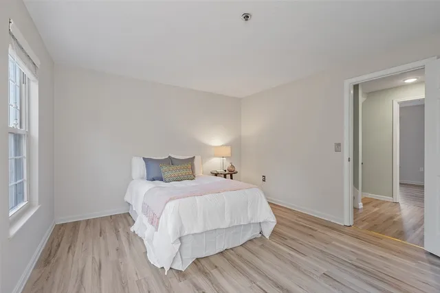 a bedroom with a bed and wooden floor