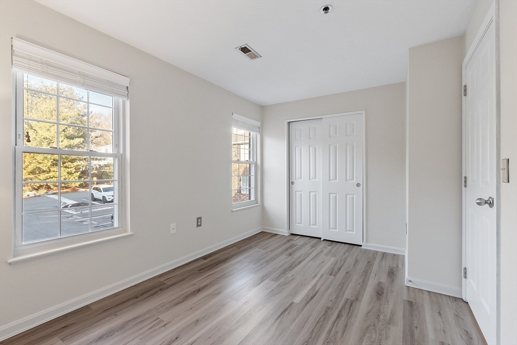 278 Manning Street, Unit 603 Hudson, MA 01749 - Photo 20 of 34 a view of empty room with wooden floor and fan