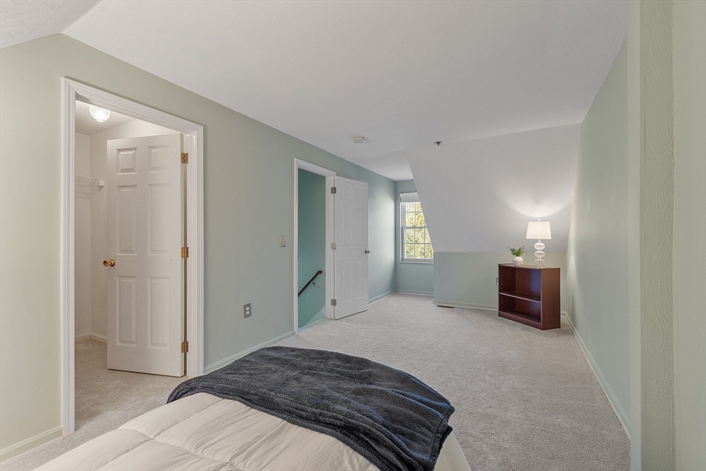 278 Manning Street, Unit 603 Hudson, MA 01749 - Photo 24 of 34 a bedroom with a bed and a lamp