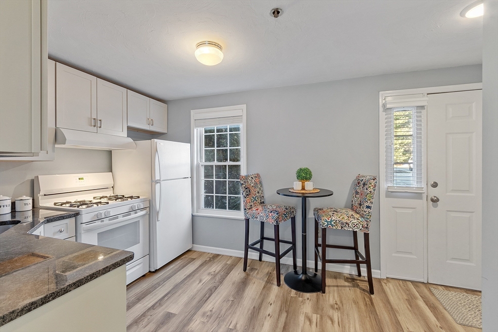 278 Manning Street, Unit 603 Hudson, MA 01749 - Photo 6 of 34 a kitchen with stainless steel appliances granite countertop a stove top oven a sink dishwasher and a dining table with wooden floor