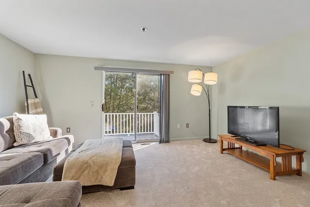 a living room with furniture a flat screen tv and a window