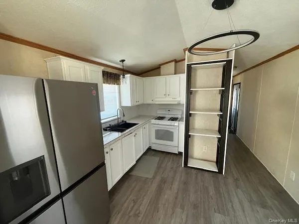 a kitchen with stainless steel appliances a refrigerator and wooden floor