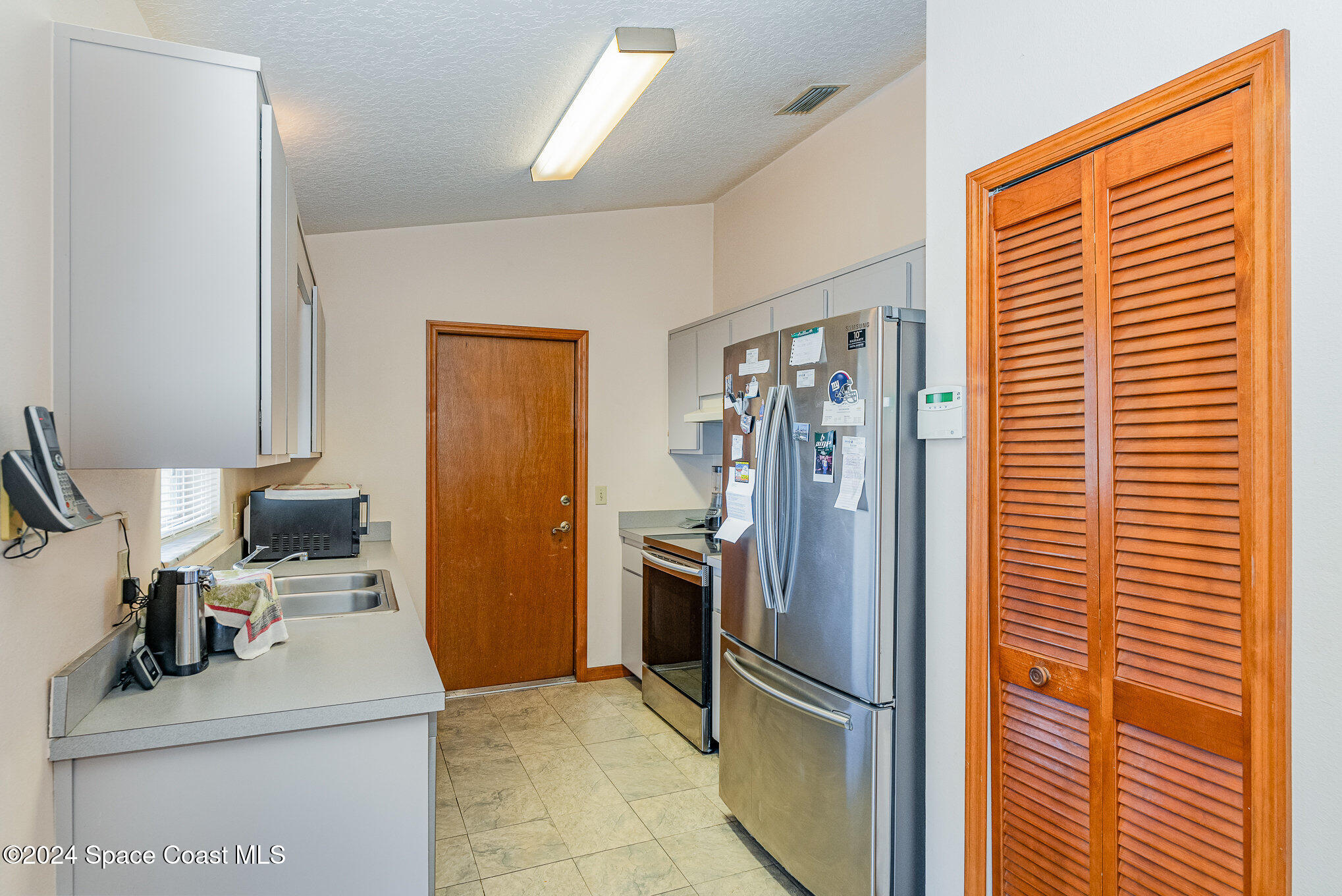 6333 Irving Road Cocoa, FL 32927 - Photo 8 of 26 a kitchen with stainless steel appliances granite countertop a refrigerator and a sink