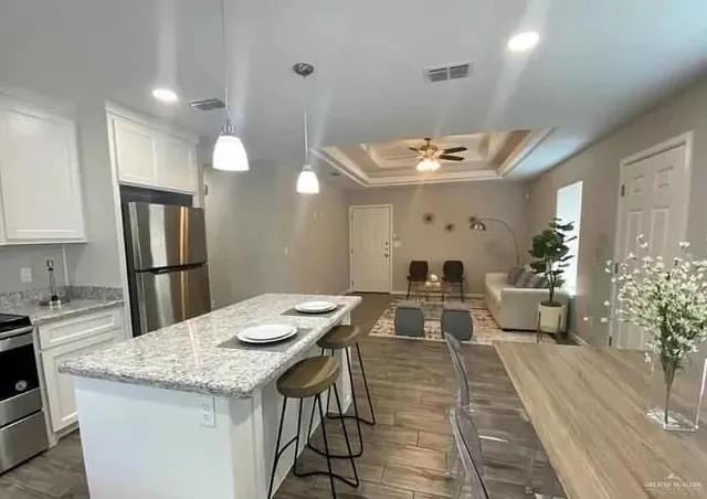 a view of a kitchen area with furniture and wooden floor