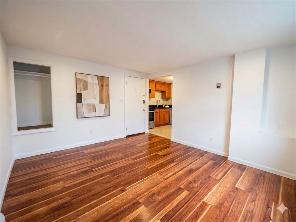 87 R Madison Street, Unit 2R Malden, MA 02148 - Photo 2 of 7 a view of empty room with wooden floor and fan