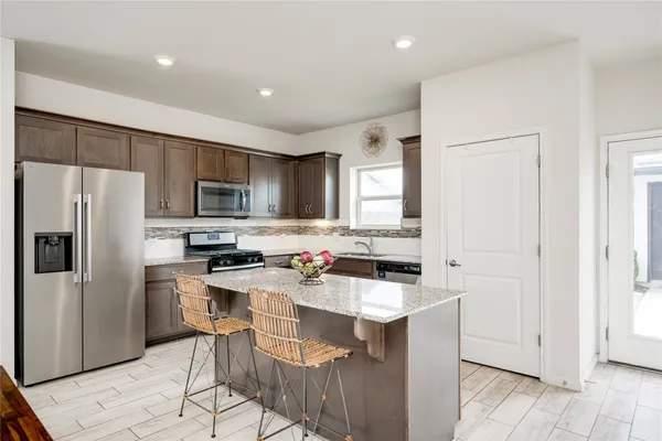 a kitchen with a sink a microwave a refrigerator and cabinets