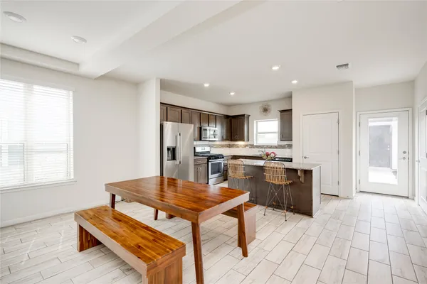 a living room with stainless steel appliances kitchen island granite countertop a stove and a sink