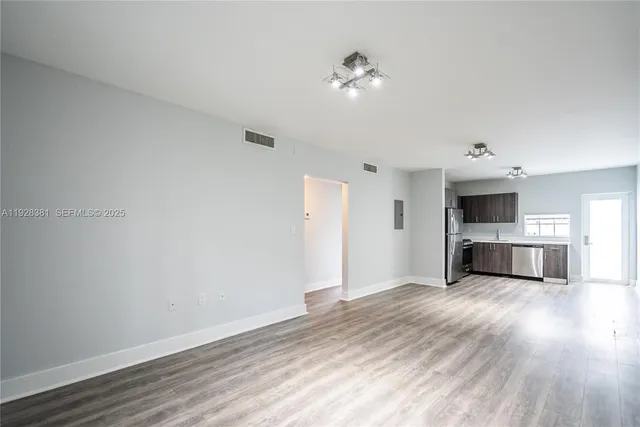 a view of a kitchen with a sink a kitchen counter space and a window