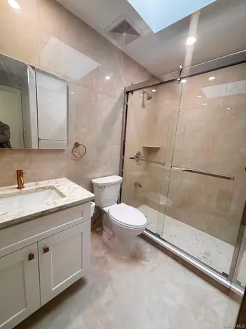 a bathroom with a granite countertop sink toilet and shower