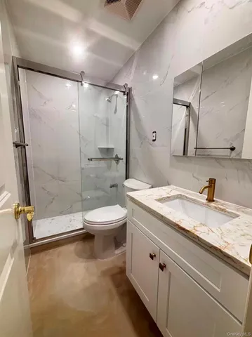 a bathroom with a granite countertop sink toilet and shower