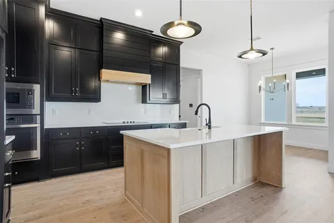 a kitchen with kitchen island a sink stainless steel appliances and cabinets