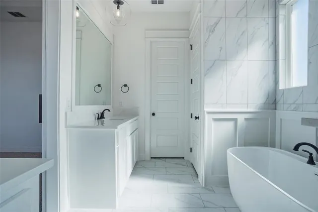 a bathroom with a tub sink and mirror