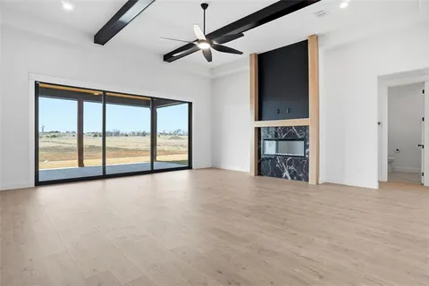 a view of an empty room with a window and a fireplace
