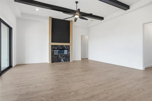 a view of an empty room with a fireplace and a window