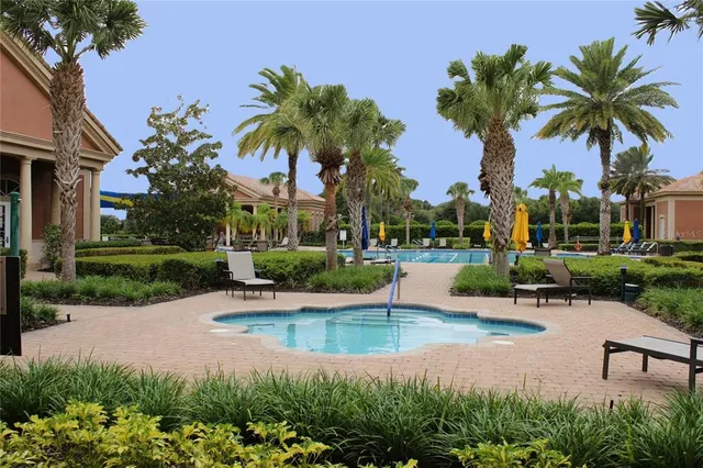 a view of a swimming pool with a yard and palm trees