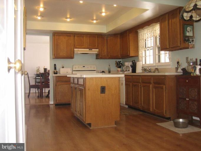 6542 Little Ox Road Fairfax Station, VA 22039 - Photo 19 of 30 a kitchen with a sink a stove cabinets and wooden floor