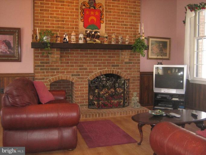 6542 Little Ox Road Fairfax Station, VA 22039 - Photo 8 of 30 a living room with furniture a flat screen tv and a fireplace